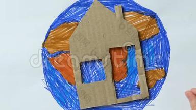 小孩把纸板房子和玩具心放在行星图片上，拯救地球