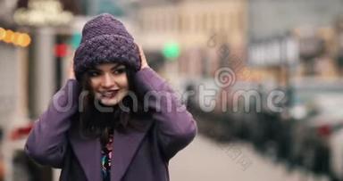穿着<strong>紫色</strong>冬帽和<strong>外套</strong>的迷人女孩用鲜艳的化妆在街上行走。