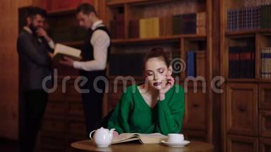 图书馆概念。 女孩翻书，在图书馆喝茶，在后台两个男人说话。