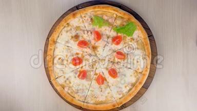 厨师把西红柿和生菜放在披萨上，鸡肉和奶酪放在木板上。 双手特写..