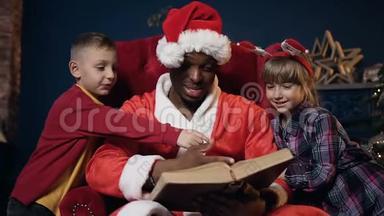 圣诞老人和两个孩子戴着红帽子<strong>看书</strong>的<strong>肖像</strong>。