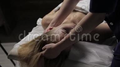 金发女人在水疗中心做头部按摩。 东方医学康塞普特，泰按摩