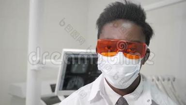 戴上<strong>医用</strong>橙色安全眼镜。 年轻的非裔美国男医生，戴着<strong>医用</strong>面具的牙医。 医学、卫生