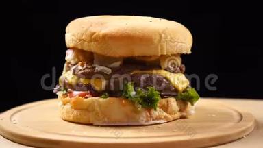 大块多汁的汉堡，里面有奶酪、酱汁和蔬菜，在黑色背景的木板上旋转