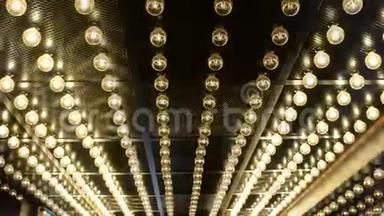 金属天花板上一个圆形大灯泡的花环闪烁着白光。