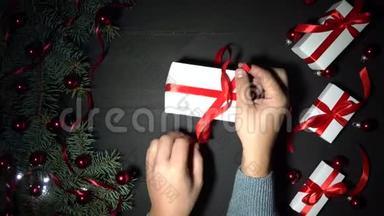 曼斯双手包一件礼物.. 黑色的圣诞背景装饰着彩灯
