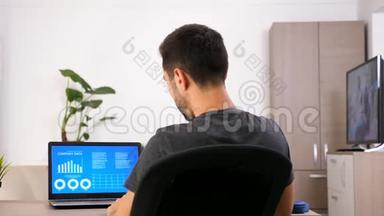 商务人士穿着休闲服装，用动画数据图表分析电脑屏幕