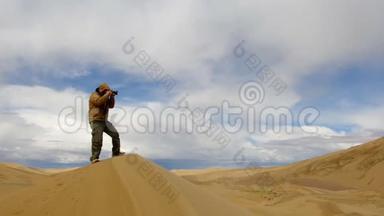 在戈壁沙漠给杜恩斯拍照的游客，