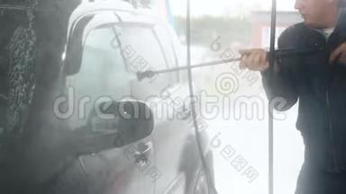 一个人洗了一辆黑色的车。 自助<strong>洗车</strong>过程中的慢动作视频。用水喷射