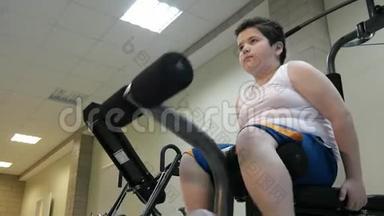 在体育馆用运动训练器材训练男孩。<strong>大</strong>肚子，减肥的概念
