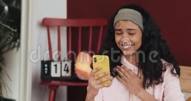 美女年轻女子用智能手机笑看惊喜享受好消息用智能手机和朋友聊天