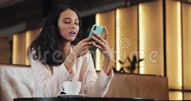 快乐的女人用智能<strong>手机</strong>说话，听声音信息。 女孩在咖啡馆里使用移动<strong>语音</strong>控制，做生意