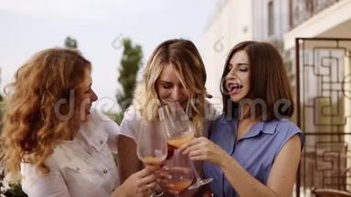 母鸡<strong>党的</strong>概念。 三个美女在露台上一起喝鸡尾酒。 女人聊天和笑。 慢慢