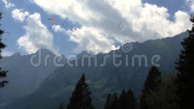 滑翔伞飞行在多洛米蒂山脉和森林从移动的椅子升降机。