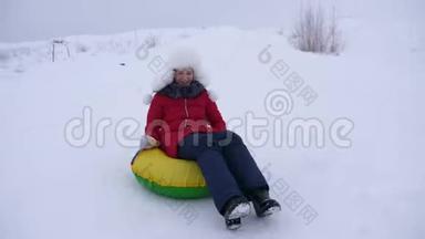 快乐的孩子滑在雪上滑在雪橇上，油管上。 女孩在公园里冬天玩。 白色的快乐少女