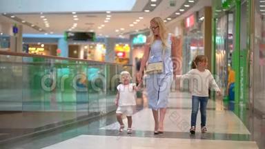 现代家庭的购物日。 孩子们在购物中心和母亲在一起。 快乐的一家人在购物。 在商场里的家人。