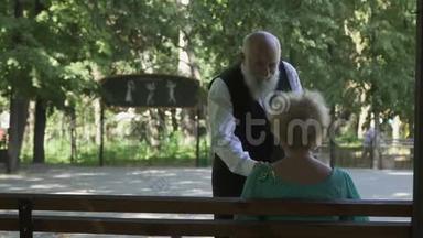 老人和美丽的妻子在公园跳华尔兹舞