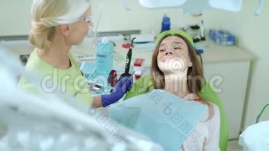 在牙医办公室做定期牙科检查的女人。 戴牙椅的快乐女孩