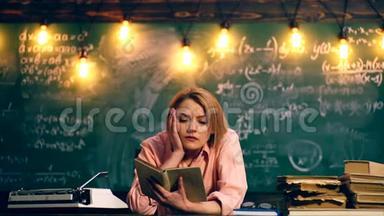 一个女人在学校班上读一本书。 学习观念。 穿制服的学童。 教室里的老师。