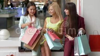 购物愉快，漂亮的女孩带着很多包，在黑色星期五坐在购物中<strong>心里</strong>享受购物的乐趣