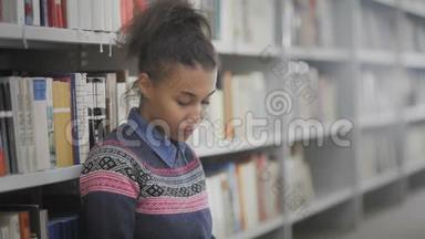 美丽的非裔<strong>美国</strong>女学生坐在学校<strong>图书馆</strong>地板上的肖像。