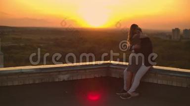 屋顶上的浪漫约会。 可爱的情侣在日落时在屋顶上约会。