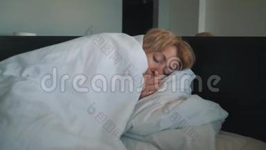 一个感冒的女人，感觉不好，吹进鼻子里，裹着一条白色的毯子。 医生`医疗帮助
