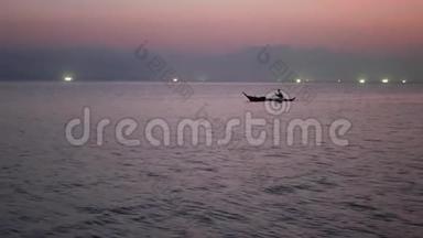 日落时分，在海上渔船灯光之间的人。 浅顶剪影航运图片