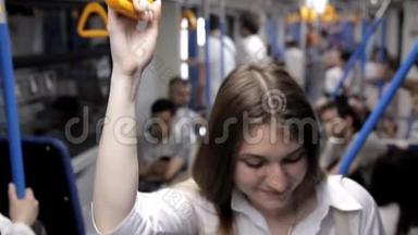 一个漂亮的女孩去<strong>地铁</strong>，握住扶手，用<strong>电话</strong>