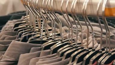 在购物中心的男装商店里，一排排各种时尚`男士衬衫在一个巨大的衣架上。