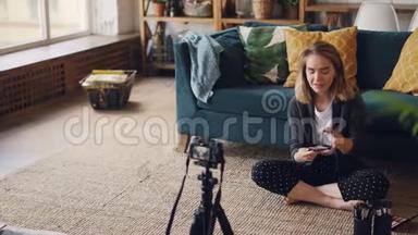 开朗的女孩vlogger<strong>正在</strong>录制关于<strong>化妆</strong>，<strong>化妆</strong>品和工具的视频，她的视频用相机。 女人是