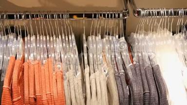 在商场或购物中心的一家服装店里，各种各样的多色女人`衣服挂在衣架上