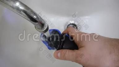 早上，人们在洗手池或洗手盆中用剃须刀清洗和清洗电动旋转剃须刀