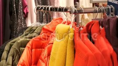 在商场或购物中心的一家服装店里，<strong>各种</strong>颜色的暖身女人`<strong>衣服</strong>挂在衣架上