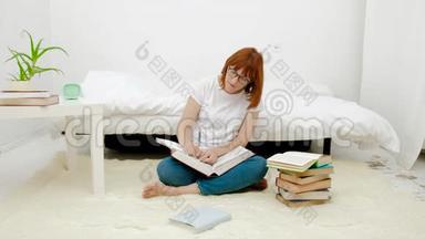 漂亮的年轻女人坐在客厅的地板上，用大量的书即兴创作