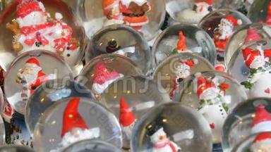 很多带有圣诞老人的装饰雪球或圣诞球。 圣诞节和新年`家庭装饰