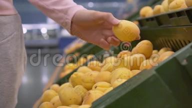 女手在超市里摘水果。