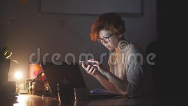 集中精力的女商人戴着眼镜，<strong>深夜</strong>在办公室里用电脑<strong>工作</strong>。