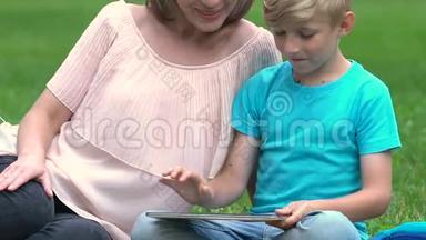 怀孕的妈妈和儿子玩平板电脑游戏，快乐的母亲，计划生育
