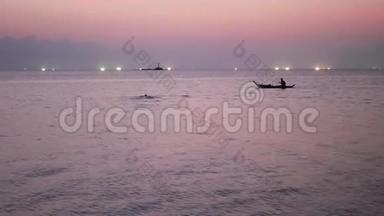 日落时分，在海上渔船灯光之间的人。 浅顶剪影航运图片