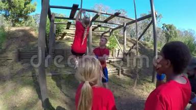 协助一名女生在4k障碍课程中<strong>爬绳</strong>的教练