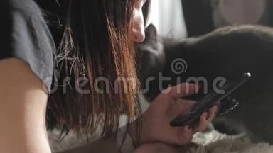 年轻女子坐在床上，用智能手机做网上购物。 网上购物的概念。
