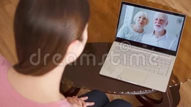 出国留学的女儿通过messenger应用程序在笔记本电脑上与父母视频聊天