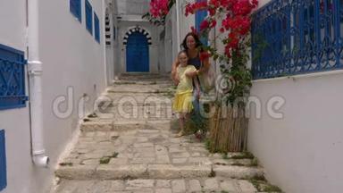 年轻的母亲和女儿在狭窄的街道背景下摆<strong>姿势拍照</strong>