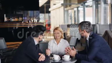 女商人在与合伙人会面时用智能手机支付午餐费用