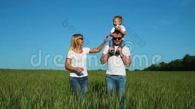 一家人在田里散步，一个孩子穿着白色T恤衫