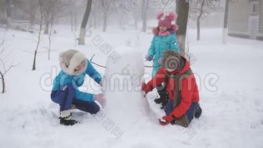 户外冬<strong>季家</strong>庭游戏。 妈妈和两个女儿一起塑<strong>造</strong>了雪人。