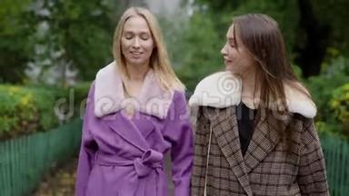 两个快乐的女孩在<strong>潮</strong>湿的秋天散步，穿着<strong>时尚</strong>的外套，年轻的女孩穿着<strong>时尚</strong>的服装。