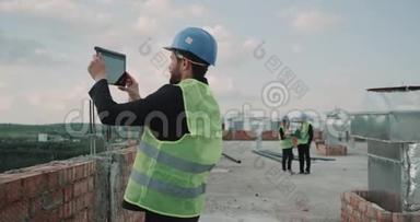 建筑师在建筑背景建筑工人的屋顶上制作图片，分析施工现场的平面图。 4k