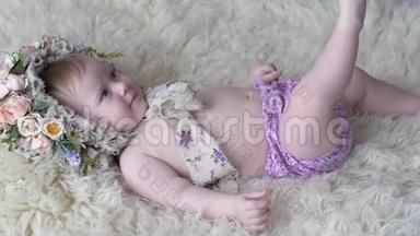 穿着花圈的漂亮小女孩躺在地毯上，在摄影镜头上摆姿势